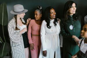 A diverse group of women smiling and standing together, embodying empowerment and diversity.