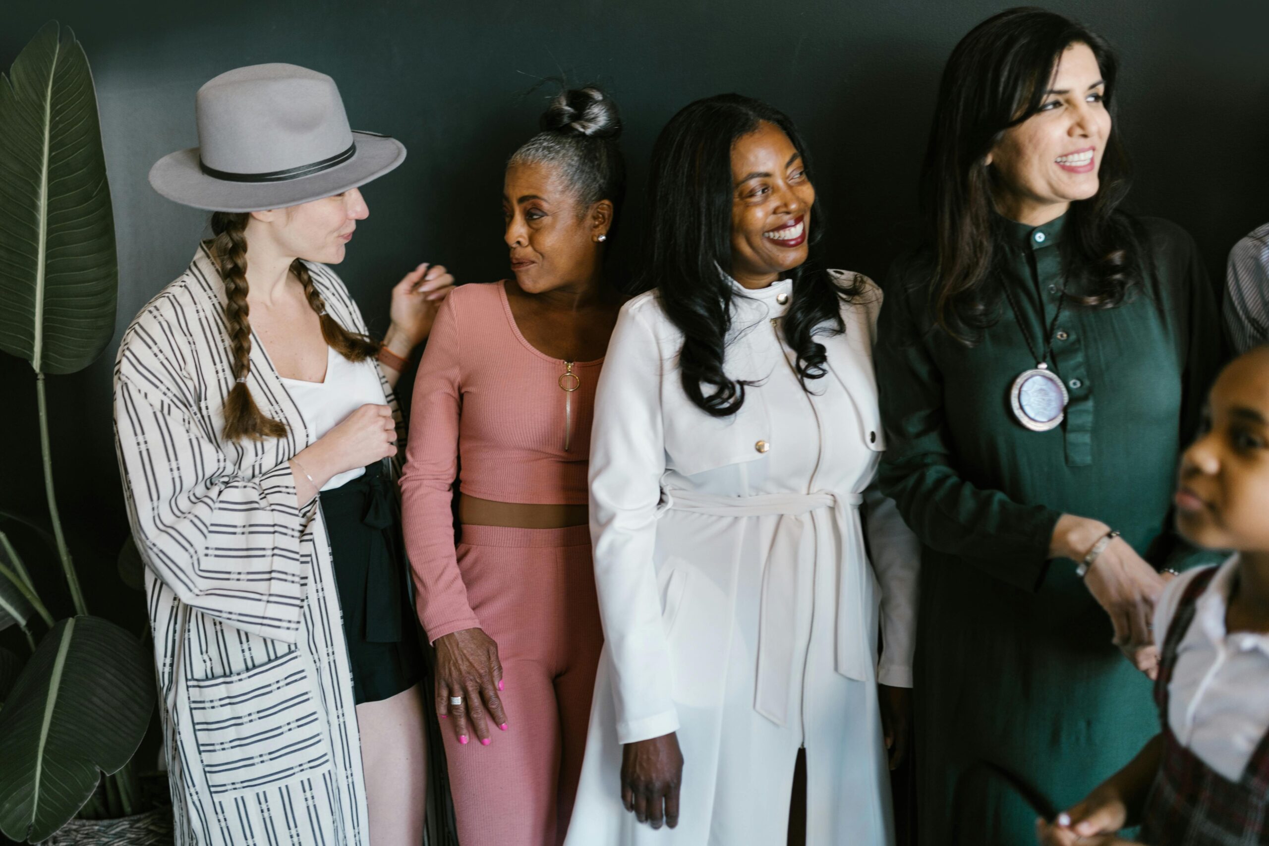 A diverse group of women smiling and standing together, embodying empowerment and diversity.