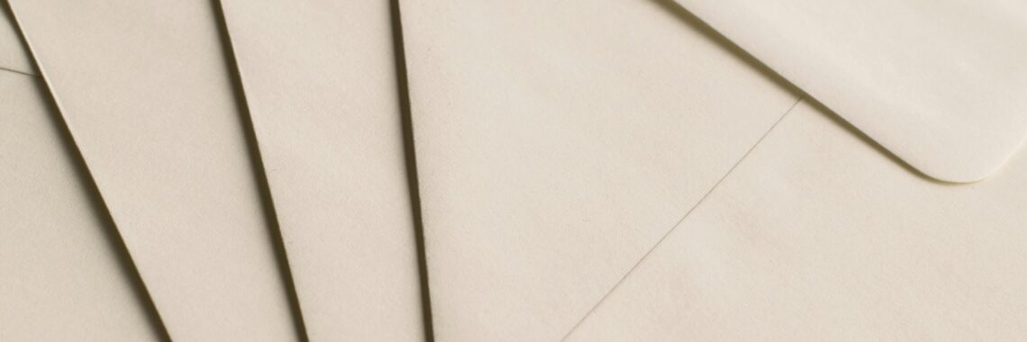 A close-up photo of beige envelopes arranged on a neutral background, ideal for stationery themes.
