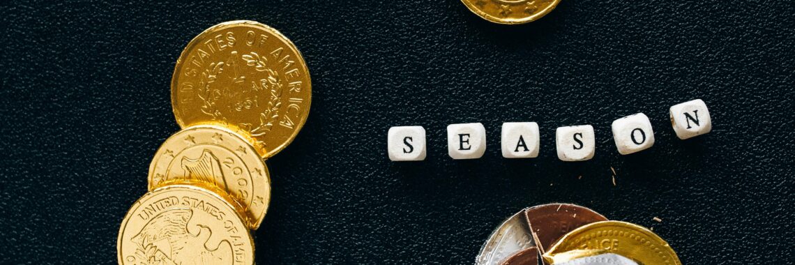 Black background highlighting gold coins and chocolate representing a tax season concept.